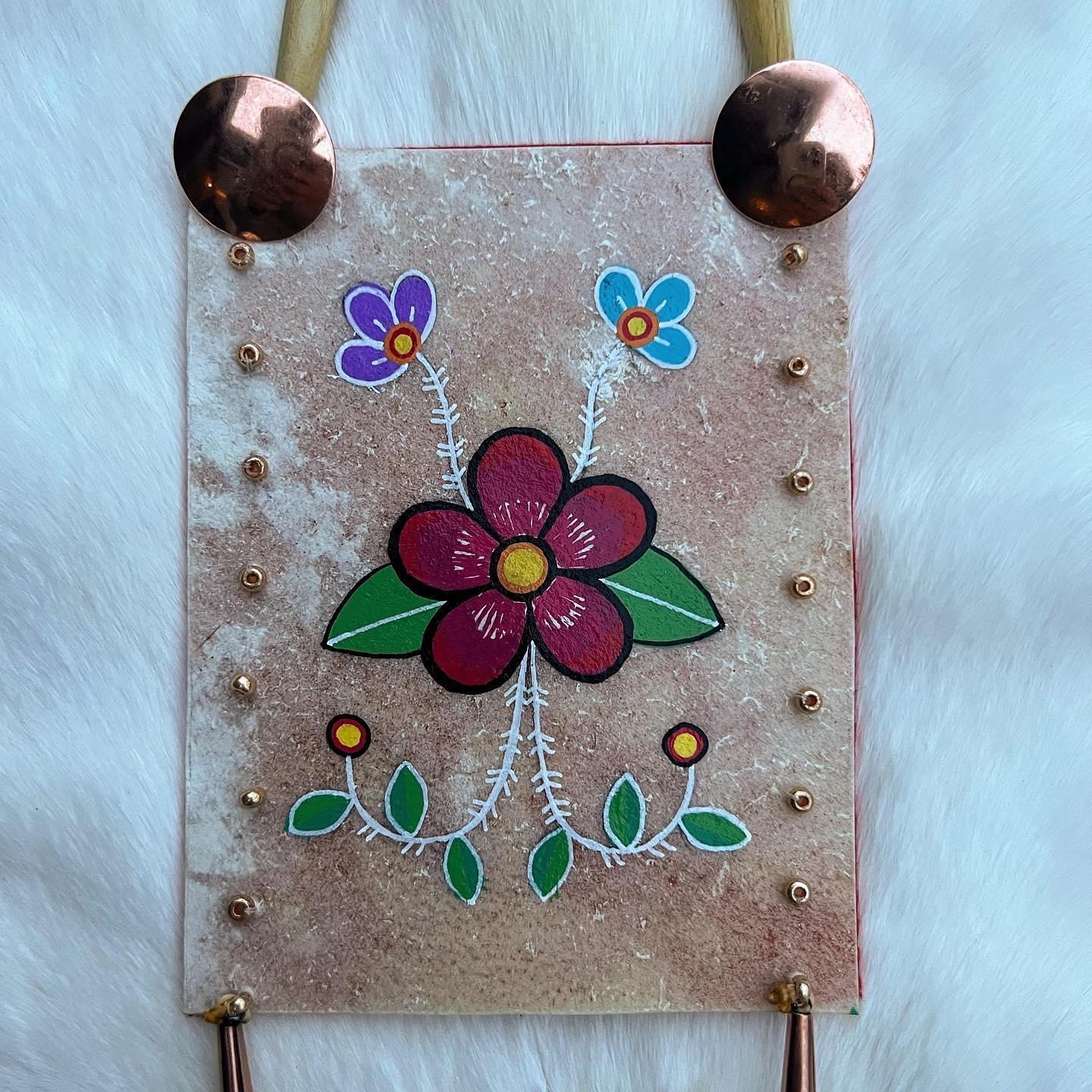 A beautiful floral parfleche necklace! It’s made with brass beads and conchos, horn pipe, and black horse hair. It’s backed in felt (it’s not a functioning pouch) and painted with Metis-style florals.
