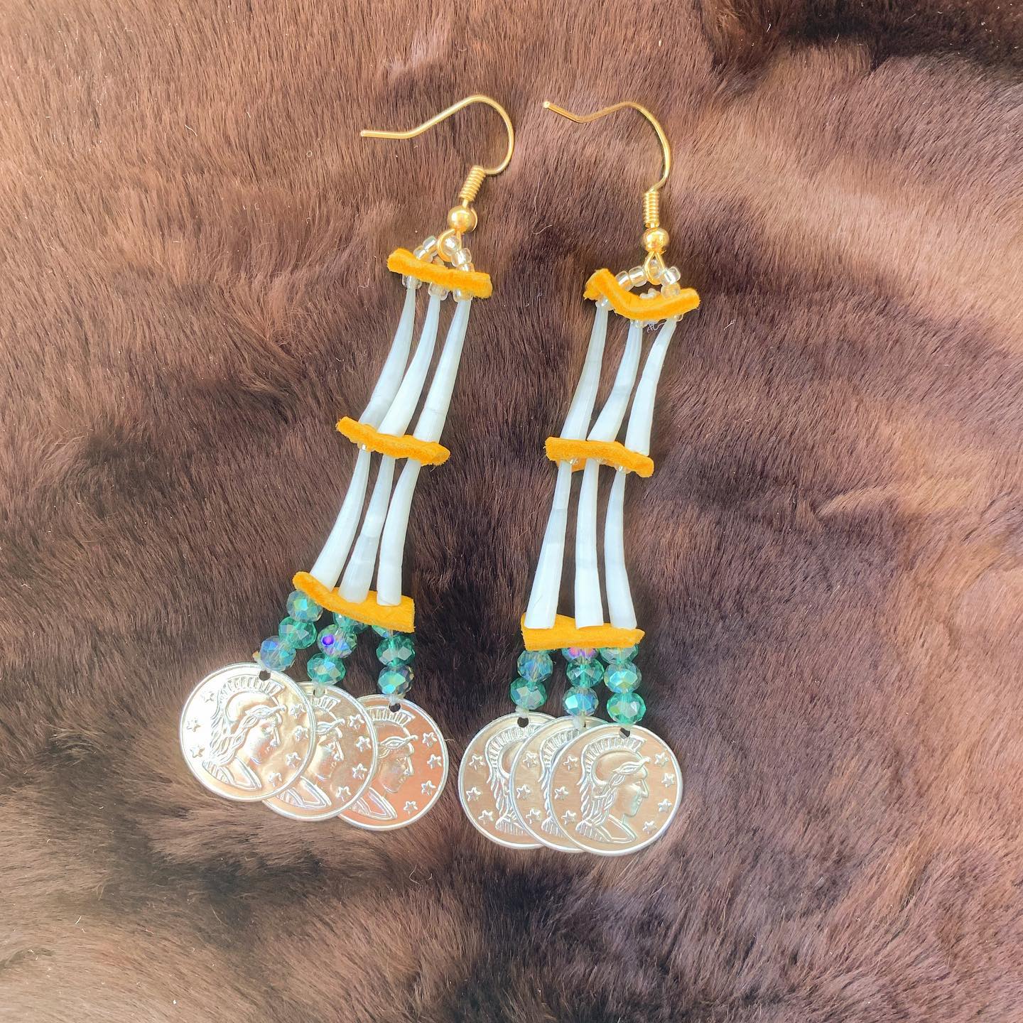 Two-tiered micro-dentalium earrings with blue glass beads and mini silver coins. Nickel-free hooks and sanded dentalium ensure longevity. These earrings are very tiny and dainty (each shell is roughly 5/8” long). Each dentalium piece was carefully sanded and shape.